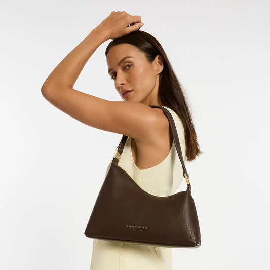 Woman with a brown leather bag on her shoulder