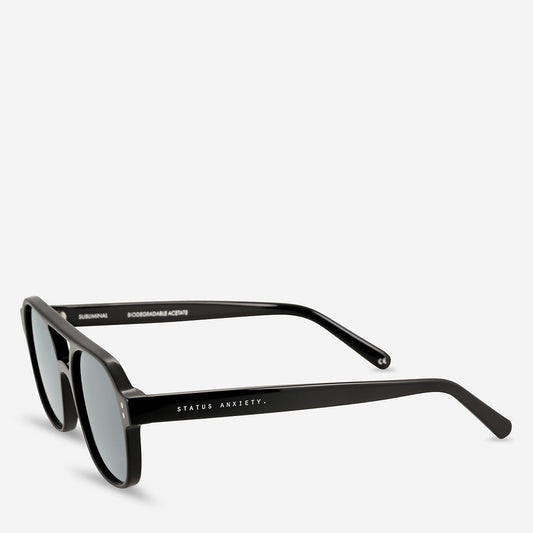 Black rectangular sunglasses shown from a three-quarter front angle, highlighting the curved frame and slim temples.