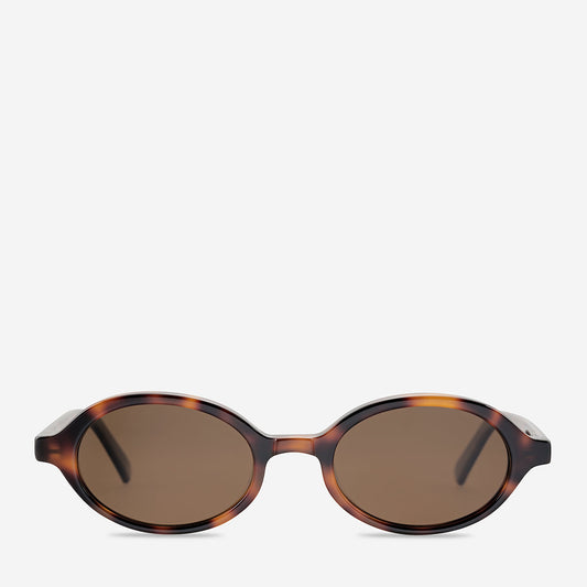 Brown tortoiseshell sunglasses shown from the front, featuring a small rounded frame, warm mottled brown colouring, softly tinted brown lenses, a narrow bridge and slim temples extending from both sides.