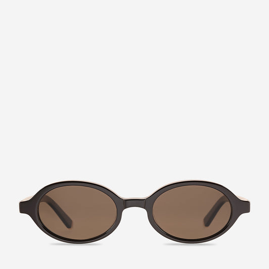 Espresso brown sunglasses shown from the front, featuring a small rounded oval frame, warm brown-tinted lenses, a slim bridge and subtle gold metal detailing near the hinges.