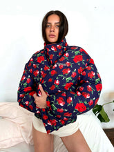 Person wearing a navy blue hoodie with red floral pattern on a white background