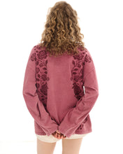 The red long-sleeve tee is shown from the back, highlighting the floral print and dropped shoulders.