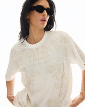 A close-up shows the crew neckline, faded Thrills logo and tonal rose artwork on the off-white T-shirt.