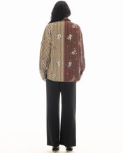 A model wears the brown and beige striped shirt in a back view showing the two-tone design and scattered embellishments.

