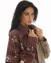 A close-up shows the pointed collar, brown and beige striped panels and floral sequin detailing.
