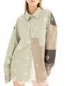 Close-up of the sage green patchwork shirt showing the pointed collar, tortoiseshell buttons, floral embellishments, contrast panels and chest pocket.