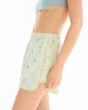 Side view of the striped runner shorts showing the loose shape, side pocket and contrasting yellow binding.