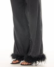 A close-up shows the subtle tonal floral pattern and black feather trimming around the pant hems.