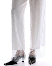 A close-up shows the delicate sheer lace panels around the hems of the white floral pants.
