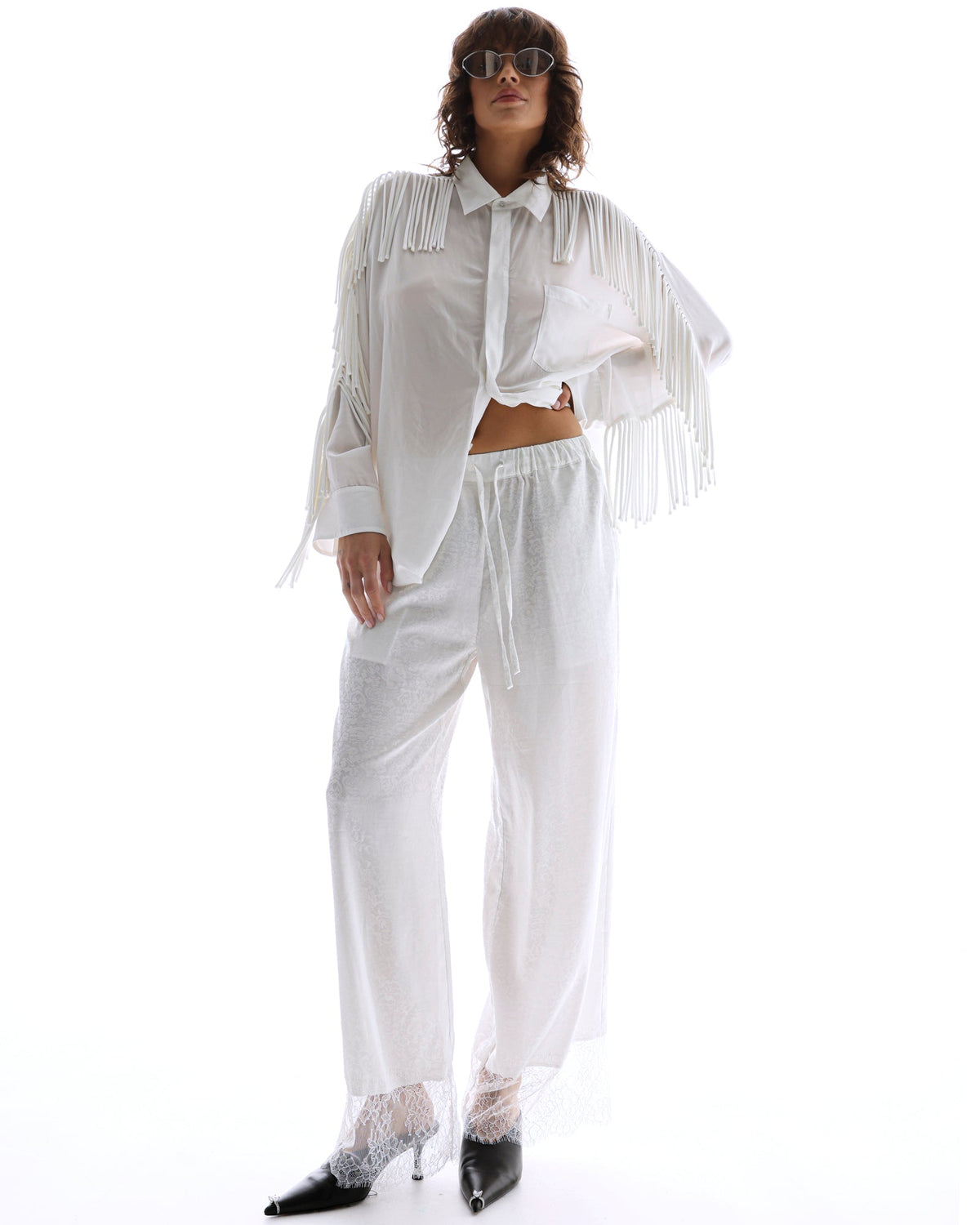 The Tales Frida Lace Hem Floral Pants in White — the Tales Frida Lace Hem Floral Pants offer an elevated take on relaxed tailoring with delicate lace trim detailing and an effortless silhouette.