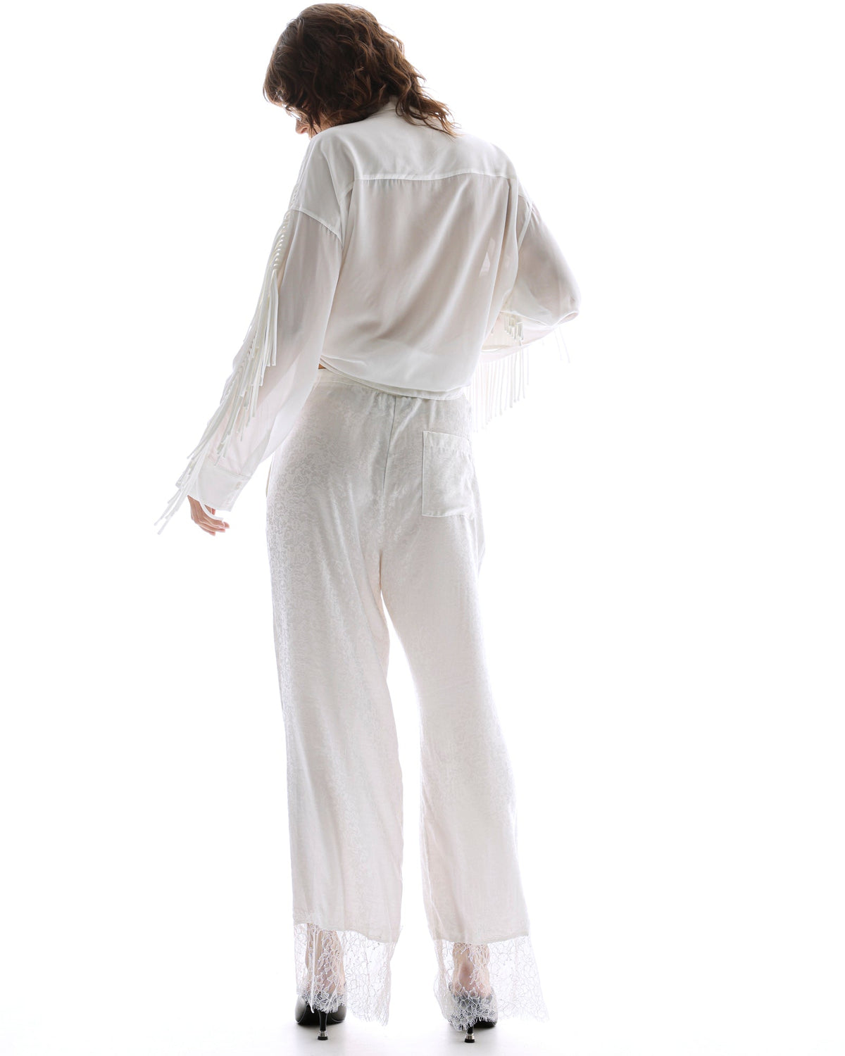 The Tales Frida Lace Hem Floral Pants in White — the Tales Frida Lace Hem Floral Pants offer an elevated take on relaxed tailoring with delicate lace trim detailing and an effortless silhouette.
