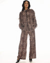 Full-length front view of the snake-print pants styled with the matching long-sleeve top and black pointed heels.