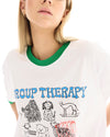 Close-up of a white T-shirt featuring a large hand-drawn dog illustration with blue and red lettering and a green ribbed neckline