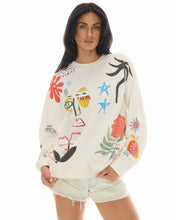 Woman wearing a cream-colored sweatshirt with colorful abstract designs on a white background