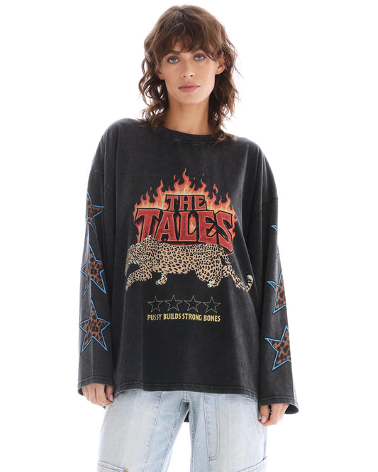Close front view of the oversized acid-wash long sleeve tee showing the flame, leopard and slogan graphic with star prints along the sleeves.