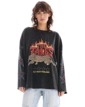 Close front view of the oversized acid-wash long sleeve tee showing the flame, leopard and slogan graphic with star prints along the sleeves.