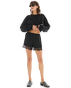 The model wears black pull-on shorts with a lace hem and cropped black top in a full front view.