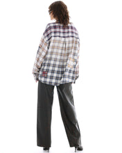 The cream mixed-plaid shirt is shown from the back, highlighting its oversized shape and patched details.