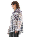 The oversized cream plaid shirt is shown from the side with long sleeves and a curved hem.