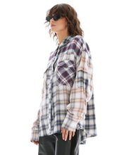 The oversized cream plaid shirt is shown from the side with long sleeves and a curved hem.