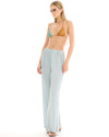Side view of a woman wearing pale ice blue wide-leg lurex pants, showing the relaxed fit and full-length hem.