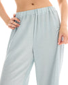 Close-up of the pale ice blue lurex pants showing the elasticated waistband and fine metallic shimmer across the fabric.