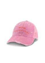 Three-quarter product view of the pink trucker cap showing the embroidered front slogan, distressed peak and mesh side panel.